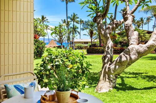 a patio with a table and a tree at Napili Shores F150 in Kapalua