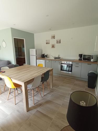 una cucina e una sala da pranzo con tavolo e sedie in legno di Logement 5 kms de Berck plage a Verton