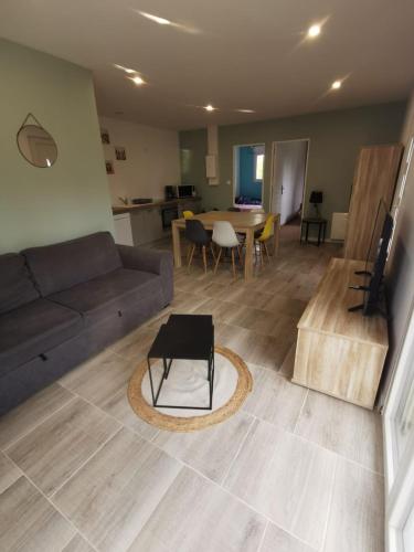 a living room with a couch and a table at Logement 5 kms de Berck plage in Verton