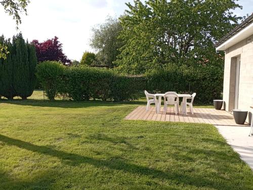 a table and chairs on a patio in a yard at Logement 5 kms de Berck plage in Verton