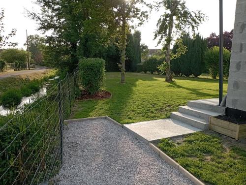 a fence in front of a yard with a lawn at Logement 5 kms de Berck plage in Verton