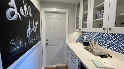 een keuken met witte kasten en een schoolbord aan de muur bij Beachcomber in New Buffalo