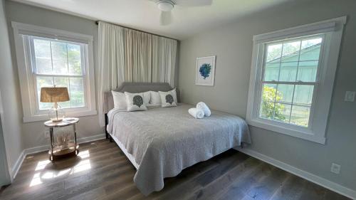 een slaapkamer met een bed en 2 ramen bij Beachcomber in New Buffalo