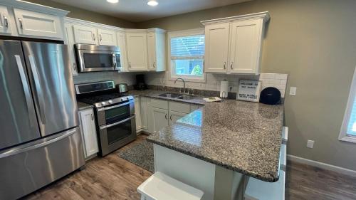 a kitchen with white cabinets and a granite counter top at The Sands in New Buffalo