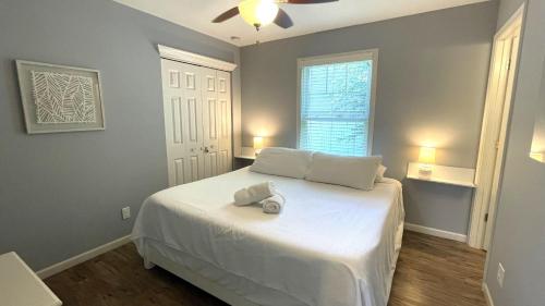 a bedroom with a bed with white sheets and a window at The Sands in New Buffalo