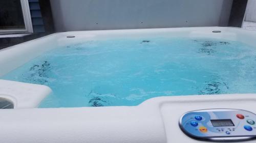 a bath tub filled with blue water with a remote control at The Sands in New Buffalo