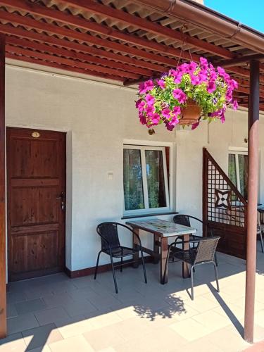 un patio con mesa, sillas y una maceta en Pokoje goscinne Jontek, en Stegna