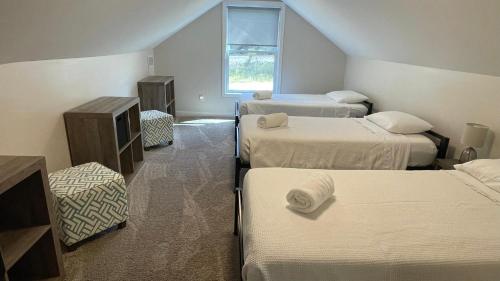 una habitación con tres camas y una ventana en White Sands, en Union Pier
