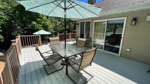 a table and chairs on a deck with an umbrella at Great Escape in New Buffalo