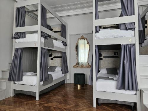 a room with three bunk beds with a mirror at The Host in Parma