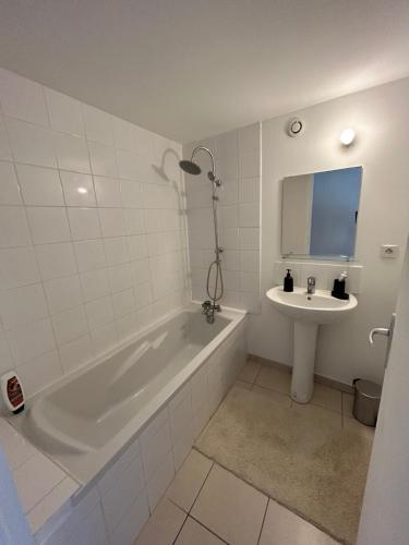 La salle de bains est pourvue d'une baignoire et d'un lavabo. dans l'établissement Charmant Appartement 2 ch Nyons-centre ville, à Nyons