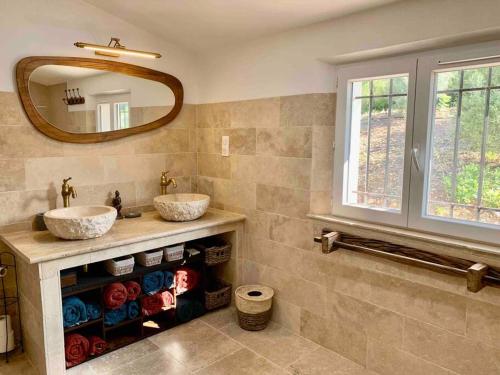 une salle de bain avec deux lavabos et un miroir dans l'établissement Maison Pipette Pipette Maison, au Castellet