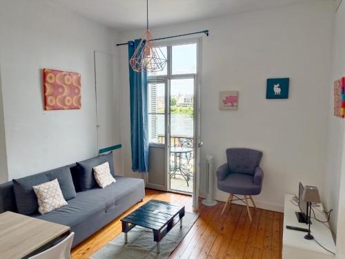 a living room with a couch and a chair at Balcon sur Loire local vélo in Saumur