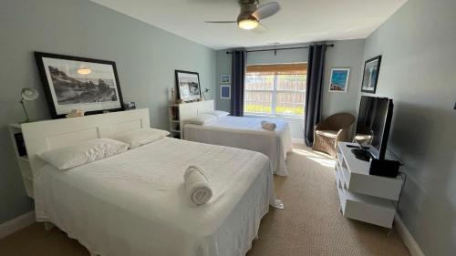a bedroom with two beds and a flat screen tv at Postcard Perfect in New Buffalo