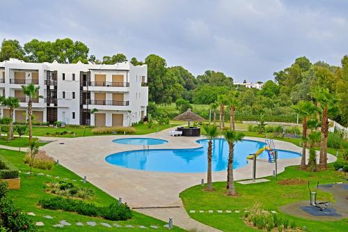 an apartment complex with a swimming pool and a building at AKS Home appart 1 - CABONEGRO in Cabo Negro