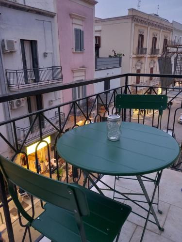 a green table and chairs on a balcony at VincesilHouse in Mola di Bari