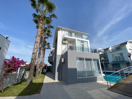 una casa con una palmera y una piscina en ANTALYA BELeK MERMAİD VİLLAS, en Belek