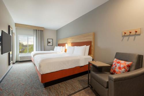 una camera d'albergo con letto e sedia di Candlewood Suites McPherson, an IHG Hotel a McPherson