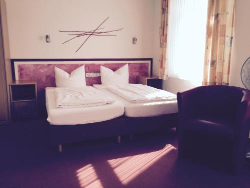 a bedroom with a large bed with white pillows at An der Porzellan-Manufaktur Pension in Meißen