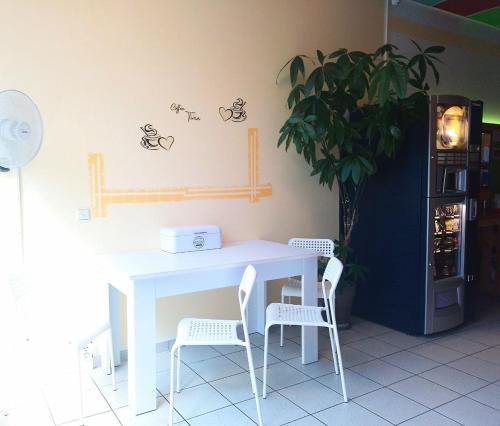 ein weißer Tisch, zwei Stühle und eine Pflanze in der Unterkunft FOX BOX I Capsule Apt in Dresden