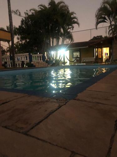 a swimming pool at night with the lights on at Chácara Sorriso 1 em Atibaia in Atibaia