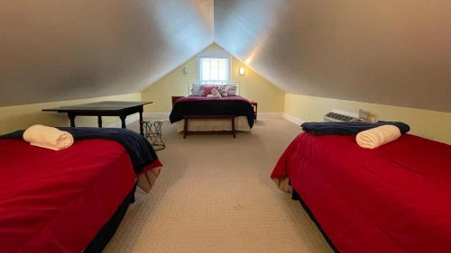 a attic room with two beds and a table at Sandy Squirrel in Union Pier