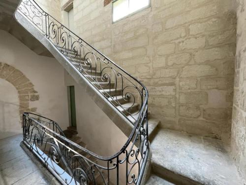 a spiral staircase in a stone building with a window at Studette avec le charme de l'ancien in Avignon