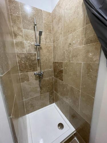 a bathroom with a shower with a tiled shower at Studette avec le charme de l'ancien in Avignon