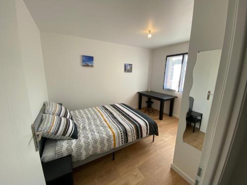 - une petite chambre avec un lit et un bureau dans l'établissement Maison plain pied Audenge 95m2 jardin privatif avec terrasses et parking, à Audenge