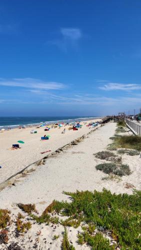 a beach with people on the sand and the ocean at Vagueira beach in Praia da Vagueira