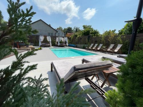 a swimming pool with chaise lounge chairs and a swimming pool at GardenLux Vrdnik in Vrdnik