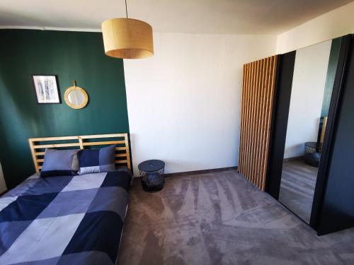 1 dormitorio con cama y pared verde en Mieszkanie Obłuże 11 piętro en Gdynia
