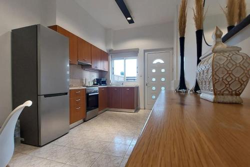 eine Küche mit einem Holztisch und einem Kühlschrank in der Unterkunft Avli House in Iraklio