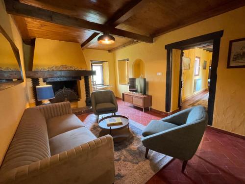 a living room with a couch and chairs and a fireplace at Val di Codena - Holiday Home in Vetto
