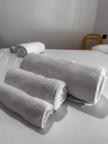 - un ensemble de serviettes laminées sur un lit dans l'établissement La Piccola Perla, à Gonnesa