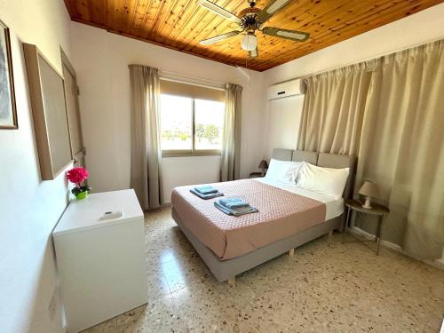 a bedroom with a bed and a ceiling fan at Himonas Apartments in Pissouri