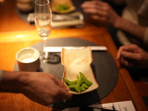 a person holding a plate of food on a table at Grand Mercure Curitiba Rayon in Curitiba