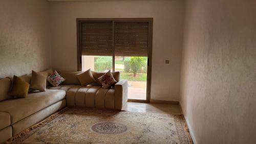 sala de estar con sofá y ventana grande en Villa de luxe residence tamaris marina 6 piscines jardin parking, en Saidia 
