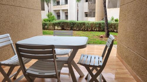 een tafel en twee stoelen en een tafel en stoelen bij Villa de luxe residence tamaris marina 6 piscines jardin parking in Saidia 