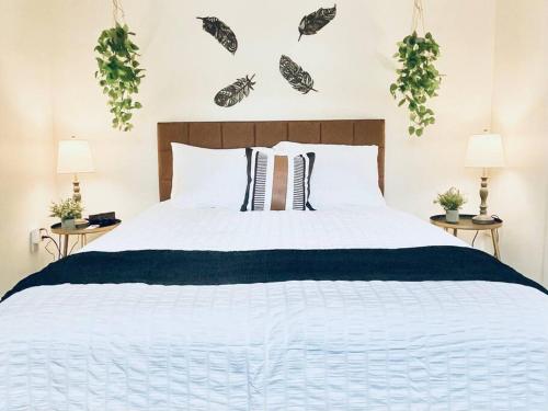 a bedroom with a large white bed with two lamps at Lady Madonna Sage Flat in Salt Lake City