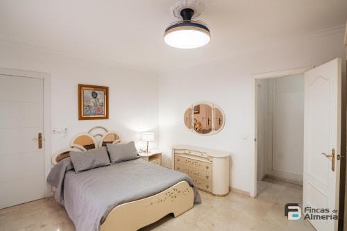 een witte slaapkamer met een bed en een spiegel bij Pedro Jover 9 R&R in Almería