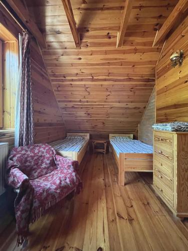a room with two beds in a log cabin at Anika dom w lesie nad jeziorem Słupinko in Dziemiany