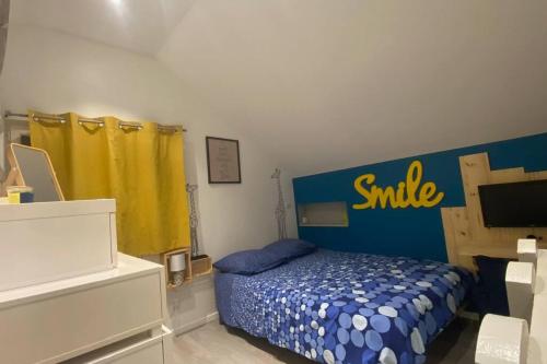 Un dormitorio con una cama azul con un signo de sonrisa. en Duplex Cosy : Moderne, Fonctionnel et Confortable, en Lans-en-Vercors