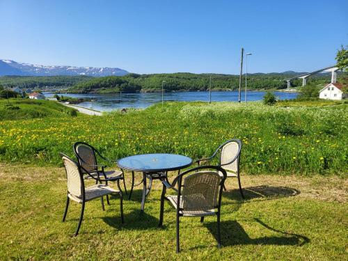 einen Tisch und vier Stühle sowie einen Tisch und Stühle in der Unterkunft Sokkelleilighet rett ved Saltstraumen in Bodø