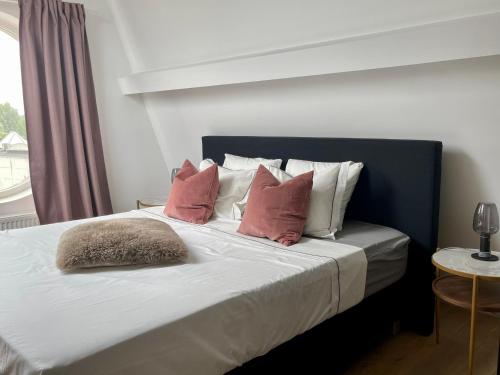 a bed with red and white pillows on it at Art Loft in Sint-Martens-Latem