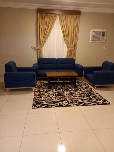 a living room with two blue couches and a table at الملاك بارك in Taif