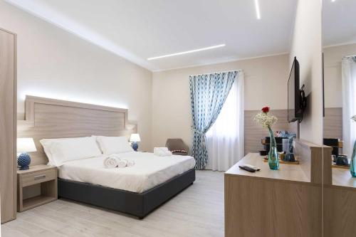 a bedroom with a bed and a desk and a window at Agorà Vulcano in Crosia