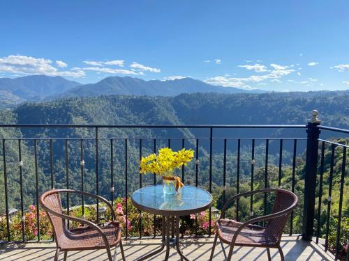 a table with chairs and a vase of flowers on a balcony at Vista Zacatlan Hotel in Zacatlán