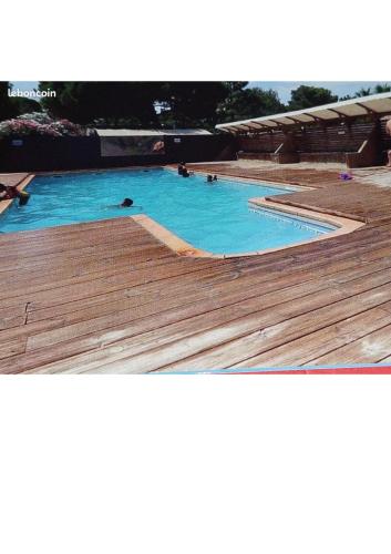 une grande piscine avec une terrasse en bois dans l'établissement Mobile home camping Pedro, au Grau-dʼAgde
