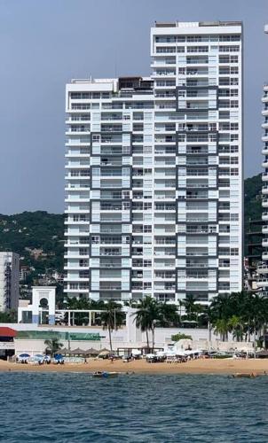 a large building next to a beach with a building at Departamento frente a la bahía in Acapulco